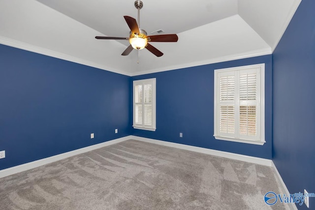 empty room with carpet floors, vaulted ceiling, ceiling fan, and crown molding