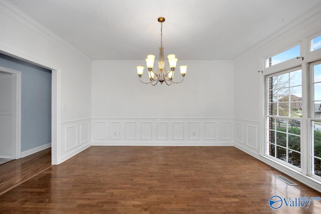 unfurnished dining area featuring crown molding, dark hardwood / wood-style floors, and a notable chandelier