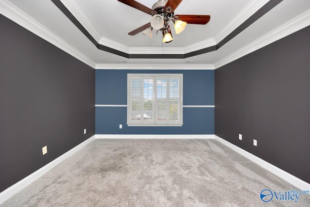 unfurnished room with a raised ceiling, crown molding, ceiling fan, and light colored carpet