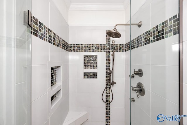 bathroom with tiled shower and ornamental molding