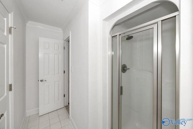 bathroom featuring tile patterned flooring, ornamental molding, and a shower with shower door