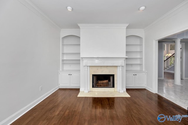 unfurnished living room with built in shelves, dark hardwood / wood-style floors, and ornamental molding