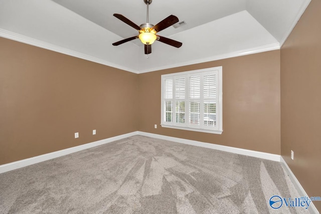 carpeted spare room with a tray ceiling, crown molding, ceiling fan, and vaulted ceiling