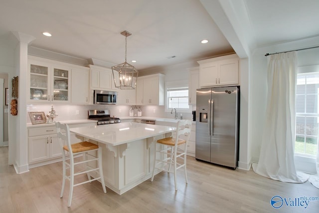 kitchen with appliances with stainless steel finishes, white cabinets, a sink, and decorative backsplash