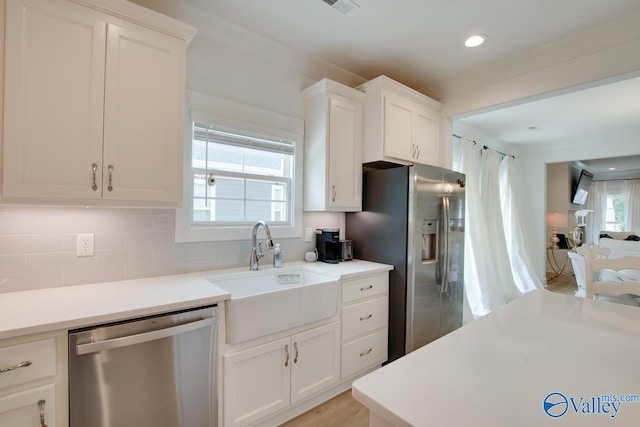 kitchen featuring light countertops, appliances with stainless steel finishes, a sink, and white cabinetry