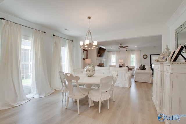 dining space with light wood-style floors, a chandelier, and a healthy amount of sunlight