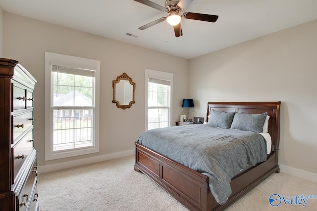 bedroom featuring baseboards, visible vents, ceiling fan, and light colored carpet