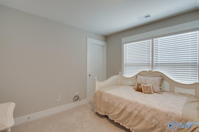 carpeted bedroom with visible vents and baseboards