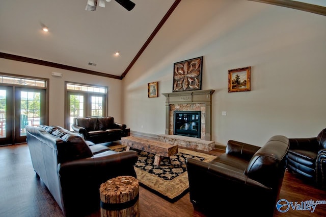 living room featuring a fireplace, crown molding, visible vents, dark wood-type flooring, and high vaulted ceiling