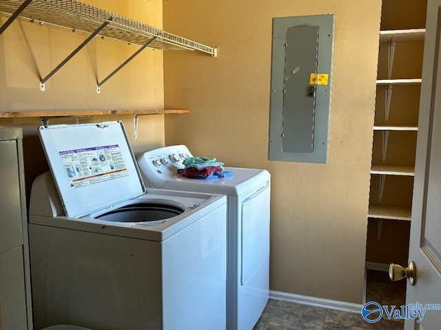 clothes washing area featuring electric panel and washing machine and dryer