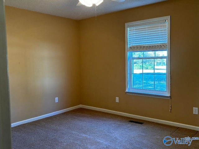 carpeted spare room with ceiling fan and a textured ceiling