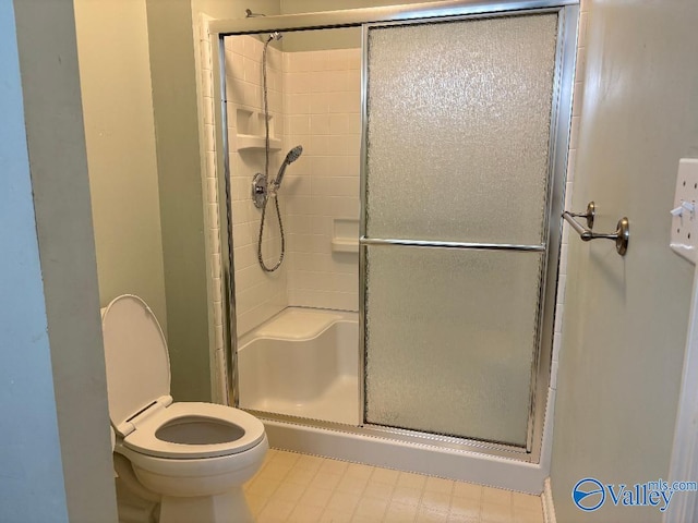 bathroom featuring toilet and an enclosed shower