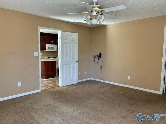 empty room with ceiling fan, carpet, and a textured ceiling