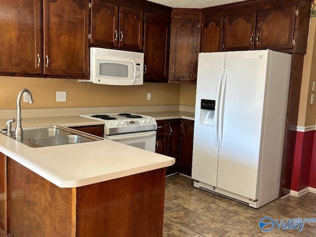 kitchen with sink, kitchen peninsula, and white appliances