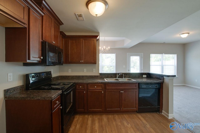 kitchen featuring an inviting chandelier, kitchen peninsula, black appliances, light colored carpet, and sink