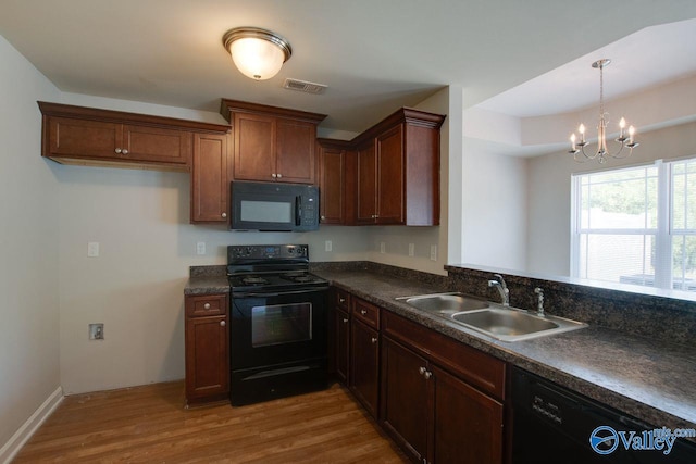 kitchen featuring sink, wood-type flooring, a chandelier, and black appliances