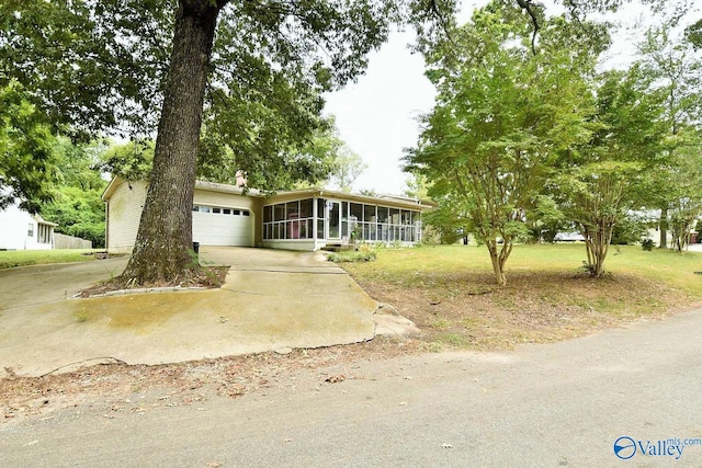 single story home with a garage, a sunroom, and a front lawn