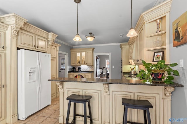 kitchen with cream cabinetry, a peninsula, tasteful backsplash, white refrigerator with ice dispenser, and light tile patterned floors
