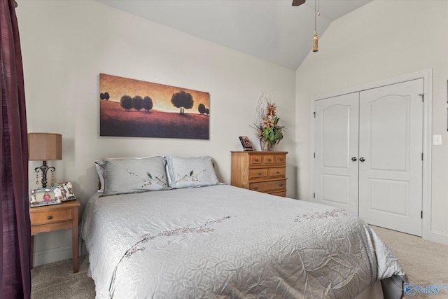 carpeted bedroom with lofted ceiling, a closet, and a ceiling fan