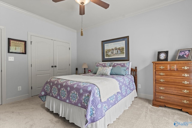 bedroom featuring ceiling fan, a closet, ornamental molding, and carpet flooring