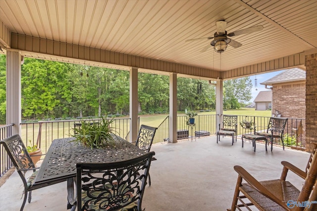 view of patio with outdoor dining area and a ceiling fan