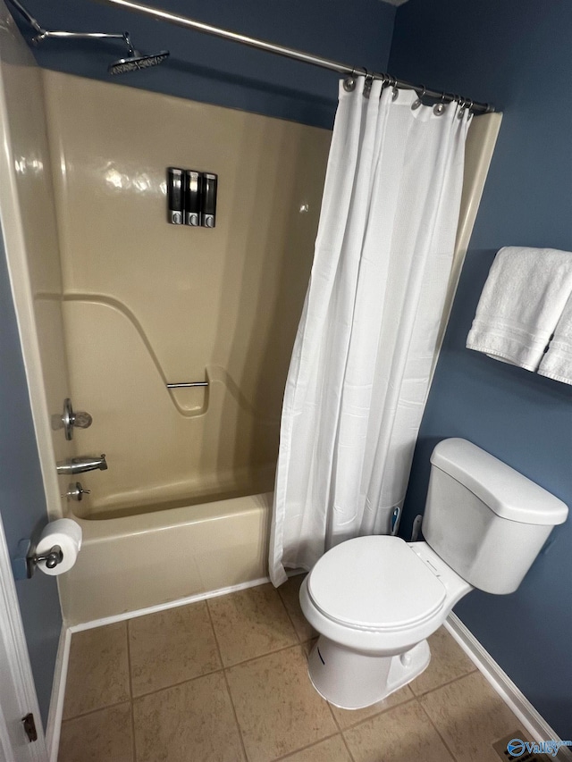 bathroom featuring baseboards, shower / bath combo, toilet, and tile patterned floors