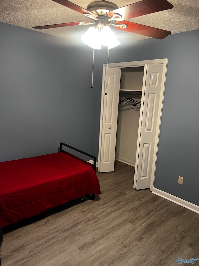 unfurnished bedroom with a textured ceiling, baseboards, and dark wood-type flooring