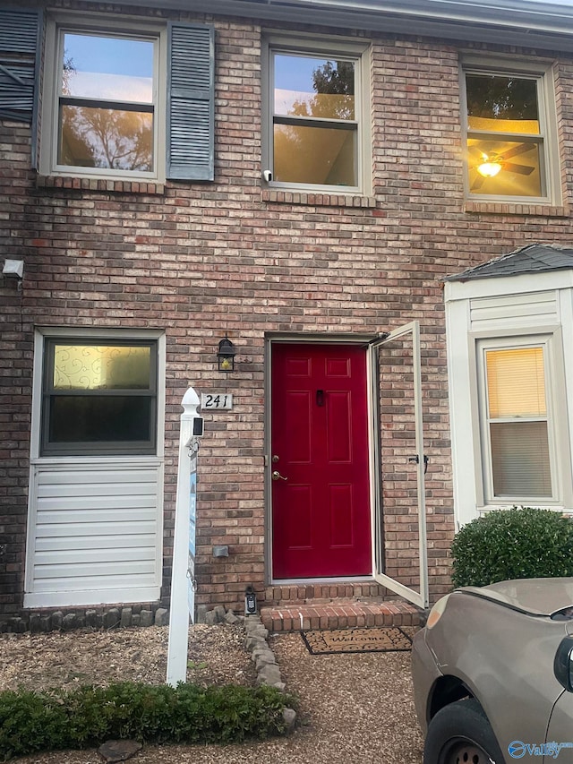 view of exterior entry featuring brick siding