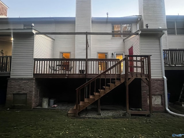 rear view of house with a yard, a chimney, stairway, and a wooden deck