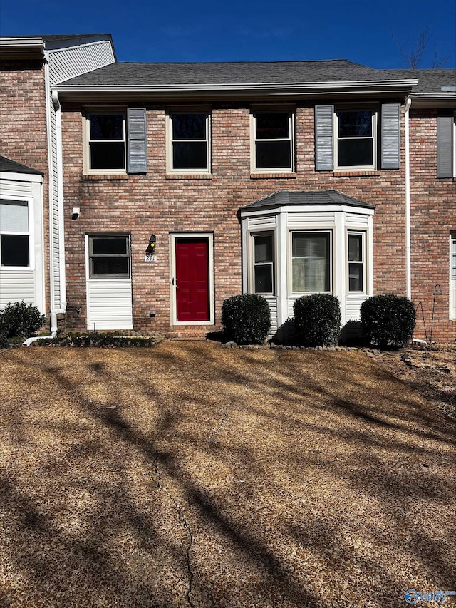 townhome / multi-family property featuring brick siding and a front yard