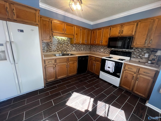 kitchen featuring a sink, black appliances, light countertops, and brown cabinets