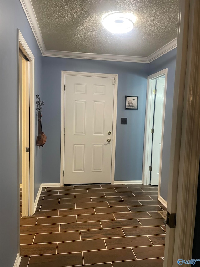 corridor with crown molding, a textured ceiling, baseboards, and wood tiled floor