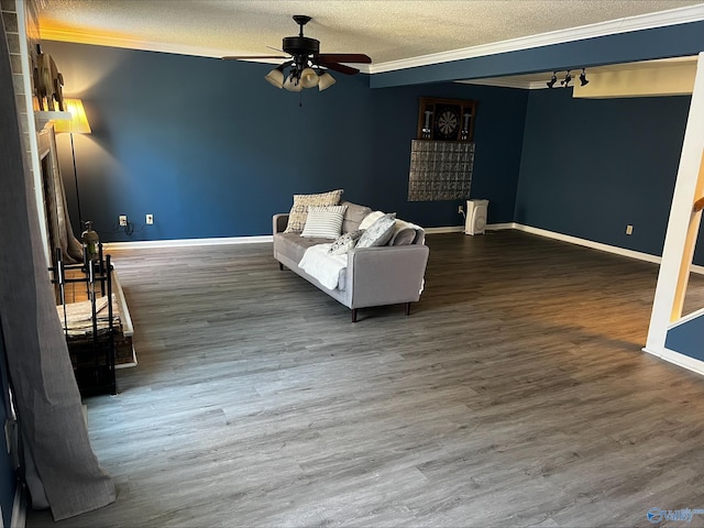 unfurnished living room featuring baseboards, ornamental molding, dark wood-style flooring, and a textured ceiling