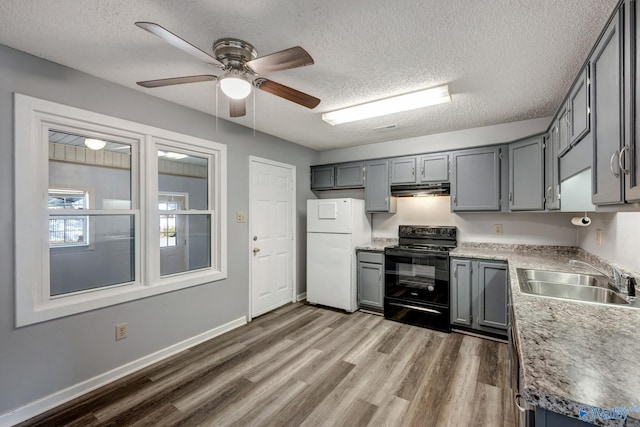 kitchen featuring black electric range, ceiling fan, hardwood / wood-style floors, white refrigerator, and sink