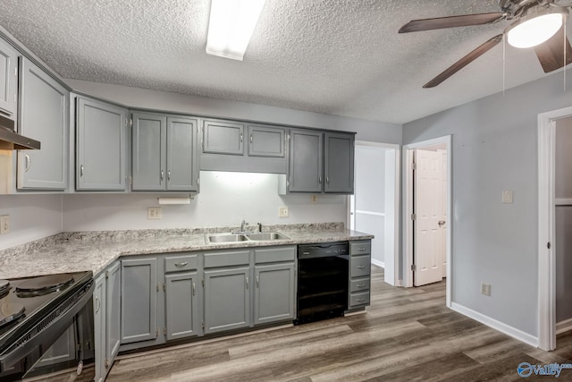 kitchen with ceiling fan, black appliances, hardwood / wood-style flooring, sink, and gray cabinetry