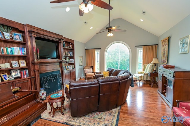 living room with high vaulted ceiling, ceiling fan, and light hardwood / wood-style floors