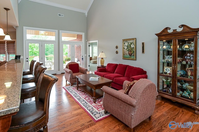 living room featuring a high ceiling, french doors, crown molding, and dark wood-type flooring