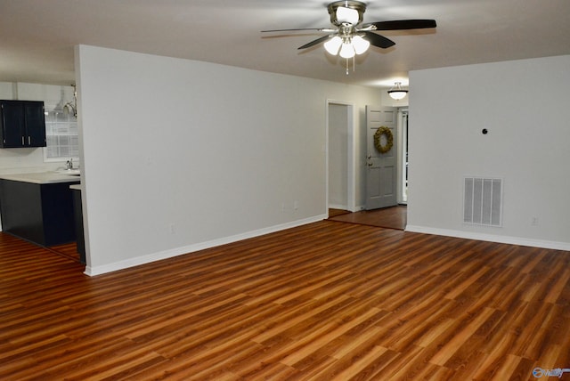 empty room with dark wood-type flooring, ceiling fan, and sink