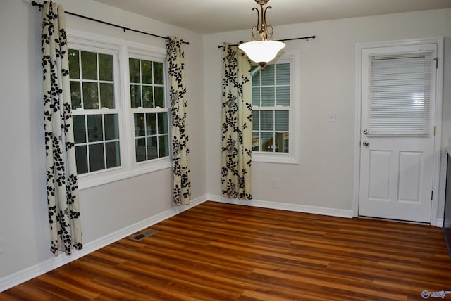 unfurnished dining area featuring dark hardwood / wood-style flooring