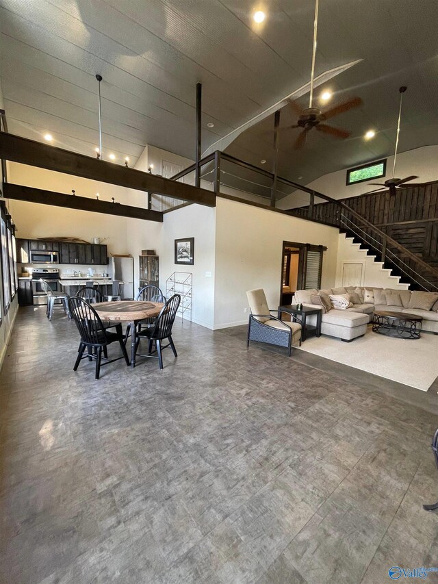 dining space featuring a towering ceiling and ceiling fan