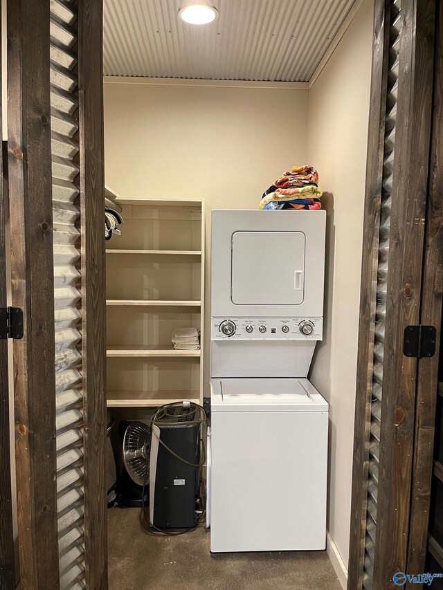 laundry room with carpet and stacked washer / drying machine