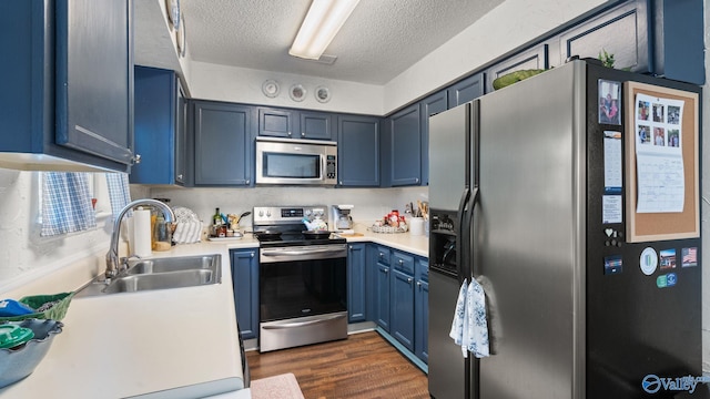 11112 Memorial Pkwy S Unit N3, Huntsville, AL 35803 - kitchen with stainless steel appliances, a sink, blue cabinetry, a textured ceiling, and light countertops