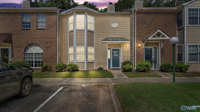 11112 Memorial Pkwy S Unit N3, Huntsville, AL 35803 - view of property featuring a chimney, brick siding, uncovered parking, and cooling unit