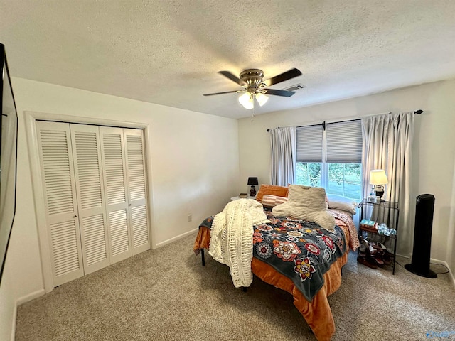 bedroom with a textured ceiling, carpet, ceiling fan, and a closet