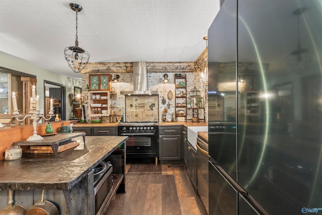 kitchen featuring hanging light fixtures, black gas range, fridge, a notable chandelier, and dark hardwood / wood-style flooring