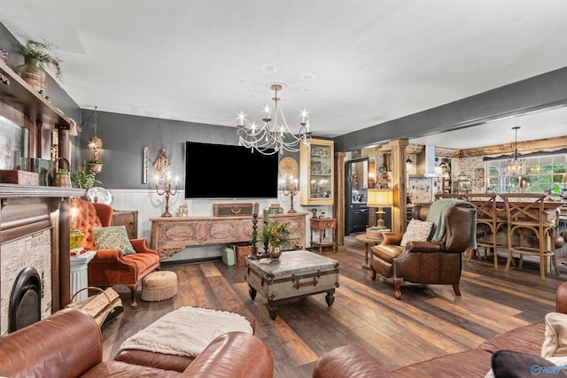 living room with a notable chandelier and dark wood-type flooring