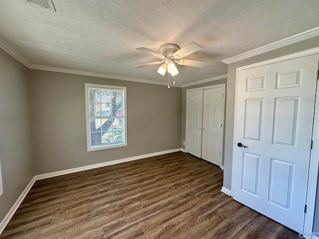 unfurnished bedroom featuring dark wood-type flooring, crown molding, a textured ceiling, and ceiling fan