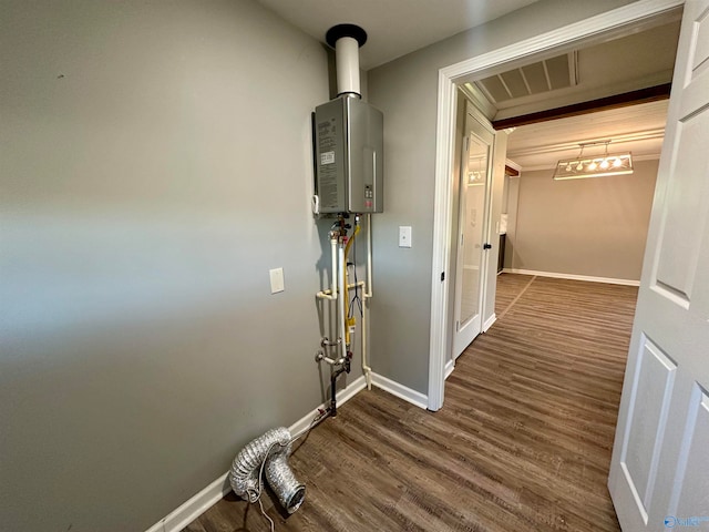 corridor featuring tankless water heater, ornamental molding, and dark hardwood / wood-style flooring