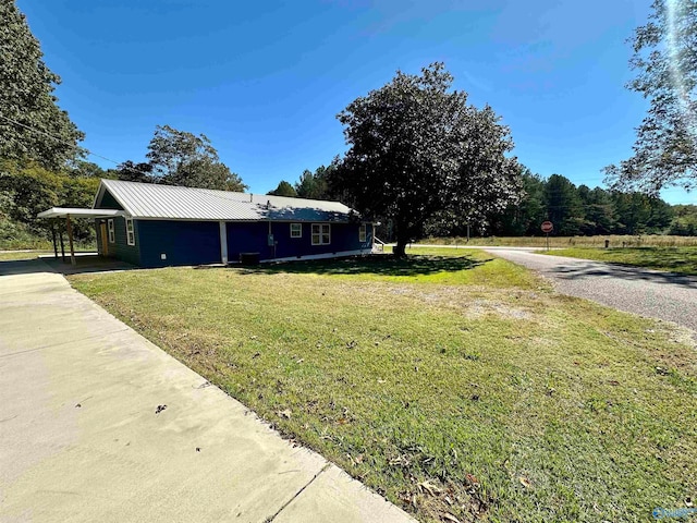 view of side of property featuring a yard and a carport