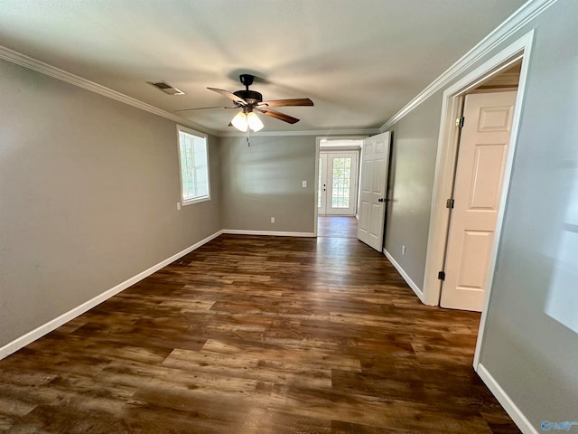 empty room featuring crown molding, dark hardwood / wood-style floors, a healthy amount of sunlight, and ceiling fan